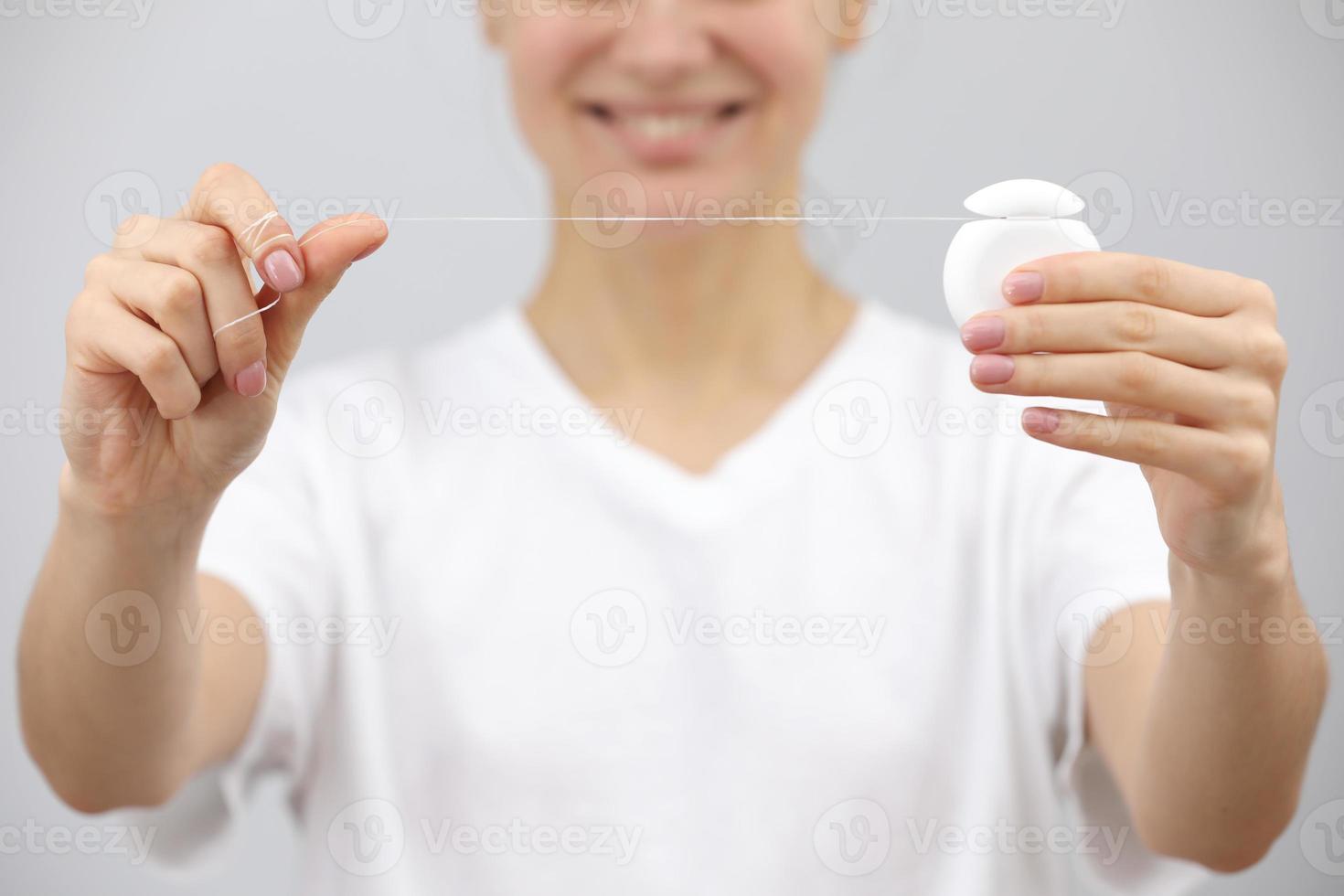 hygiène et soins dentaires. fil dentaire. visage de jeune femme en bonne santé avec un sourire de beauté. brosse à dents. nettoyage buccal, blanchiment. belle fille. soins de santé de la personne. femme le matin dans la salle de bain. photo