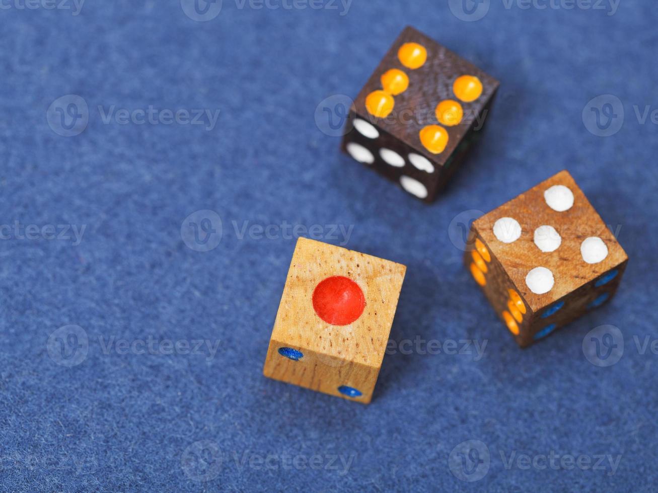 trois dés de jeu en bois sur tissu bleu photo