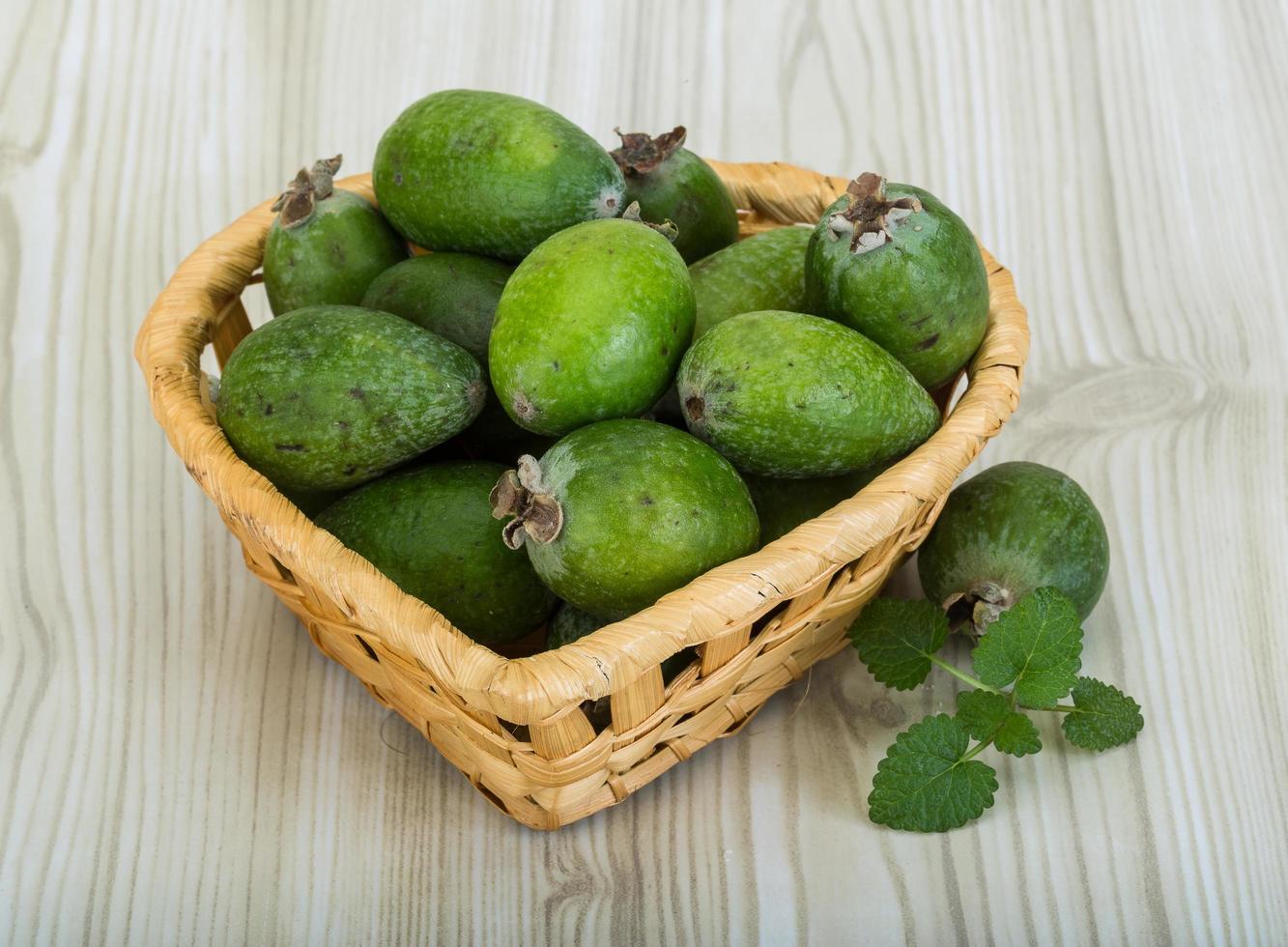 Feijoa dans un panier sur fond de bois photo