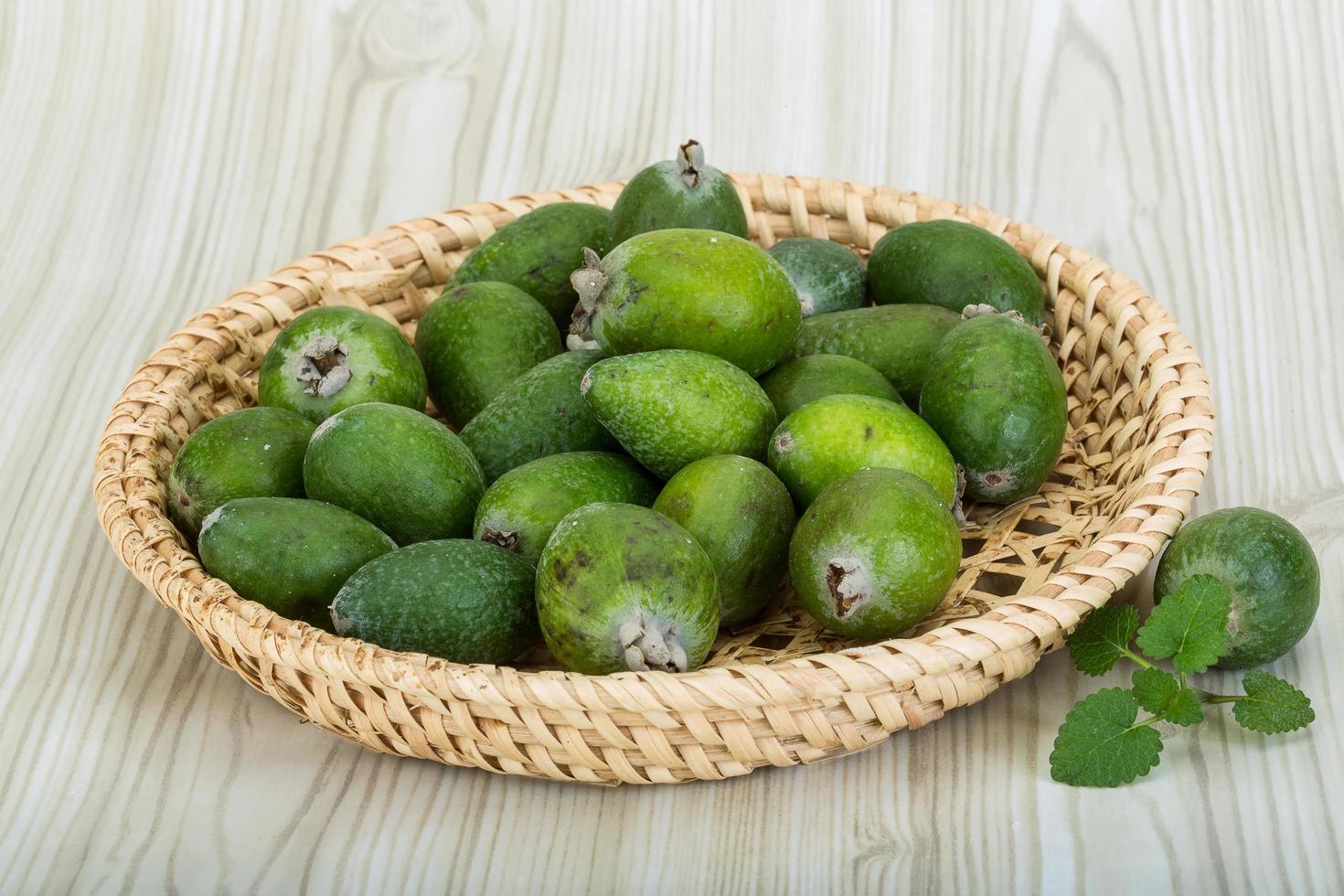 Feijoa dans un panier sur fond de bois photo