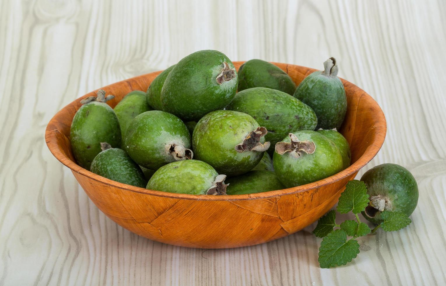 Feijoa dans un bol sur fond de bois photo