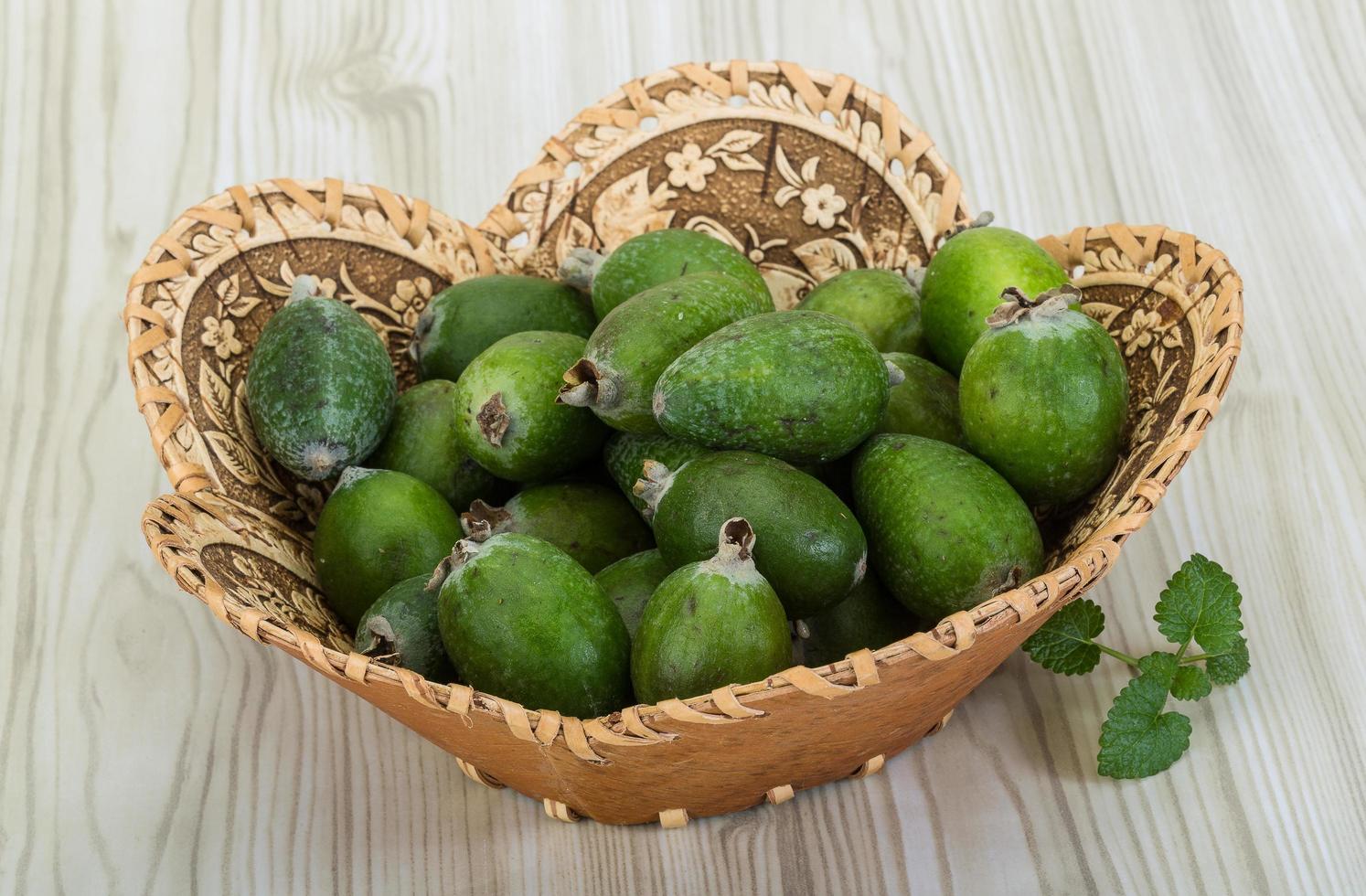 Feijoa dans un panier sur fond de bois photo