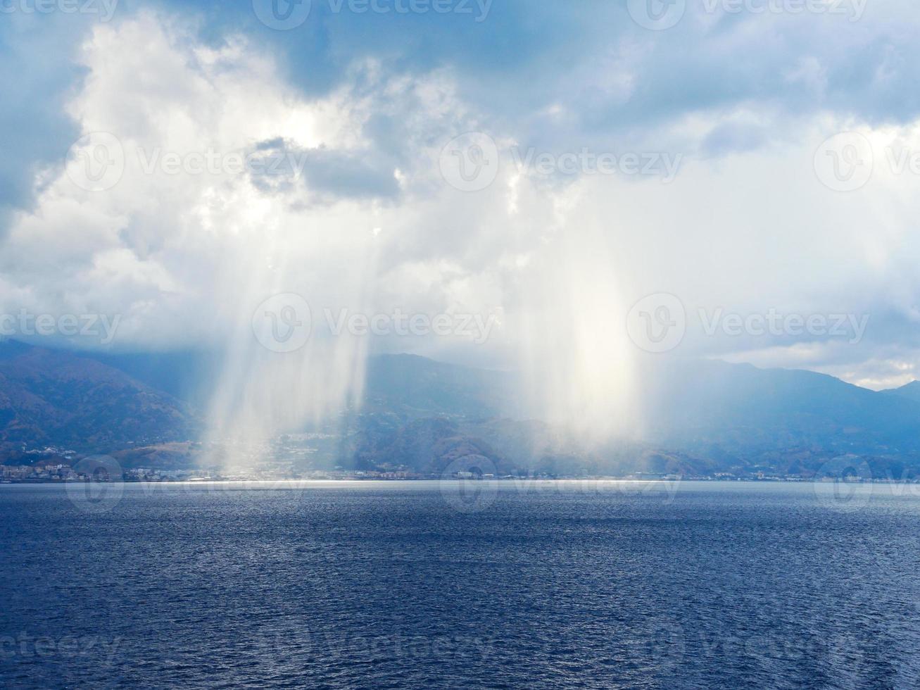 rayons de soleil traversant les nuages en mer photo