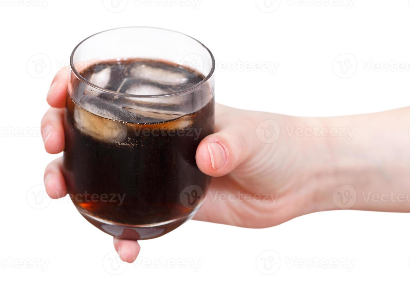 main tenant du cola avec de la glace dans du verre photo