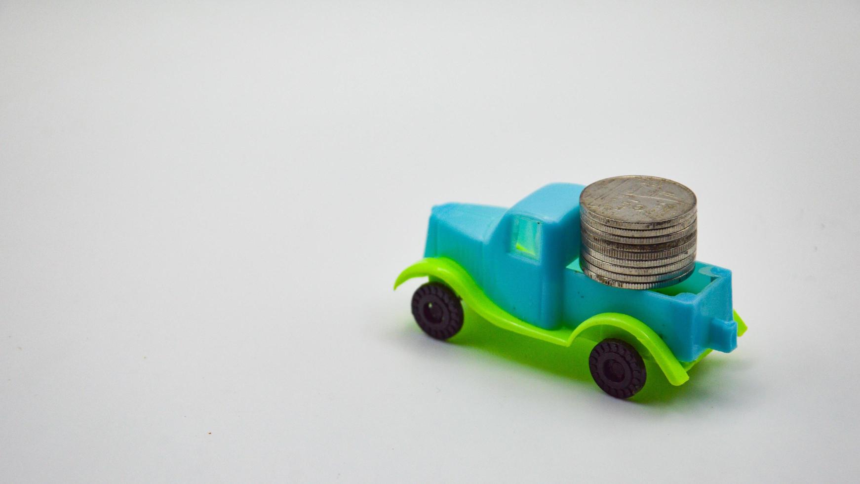 pièces d'argent empilées sur un camion bleu-vert. concept de fond blanc police d'assurance automobile affaires financières photo