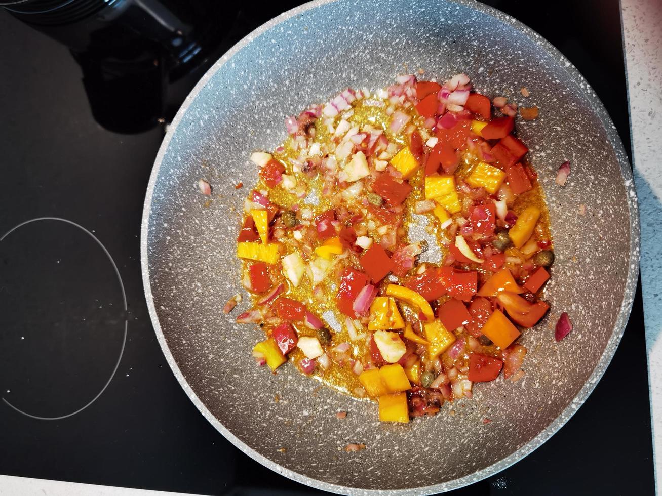 sautés dans une poêle de poivrons tomates et oignons pour une entrée de pâtes de restaurant photo