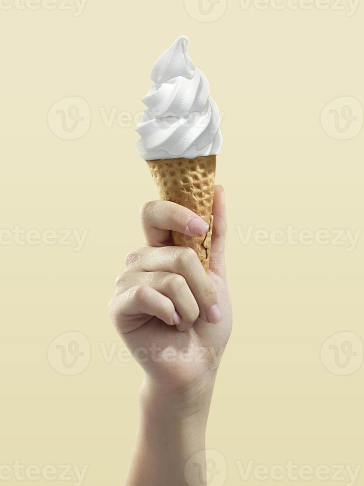 cornet de crème glacée sur fond jaune, femme tenant une glace à la main photo