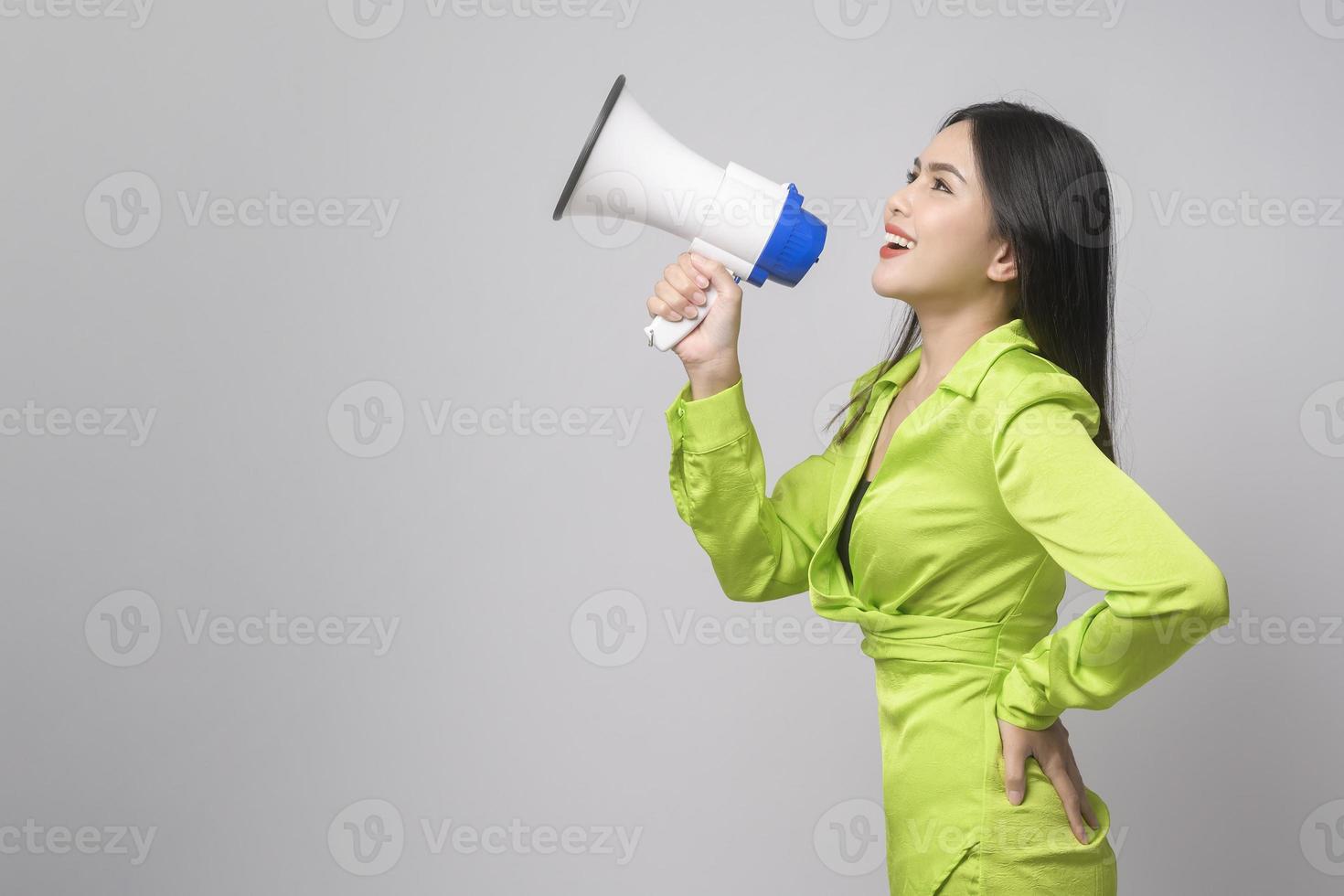 belle jeune femme tenant un mégaphone sur fond blanc studio. photo