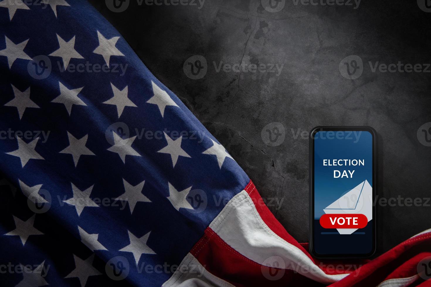 jour des élections dans le concept des états-unis. spectacle de vote en ligne sur l'écran du téléphone mobile. smartphone allongé sur fond de ciment et drapeau américain à proximité. vue de dessus photo