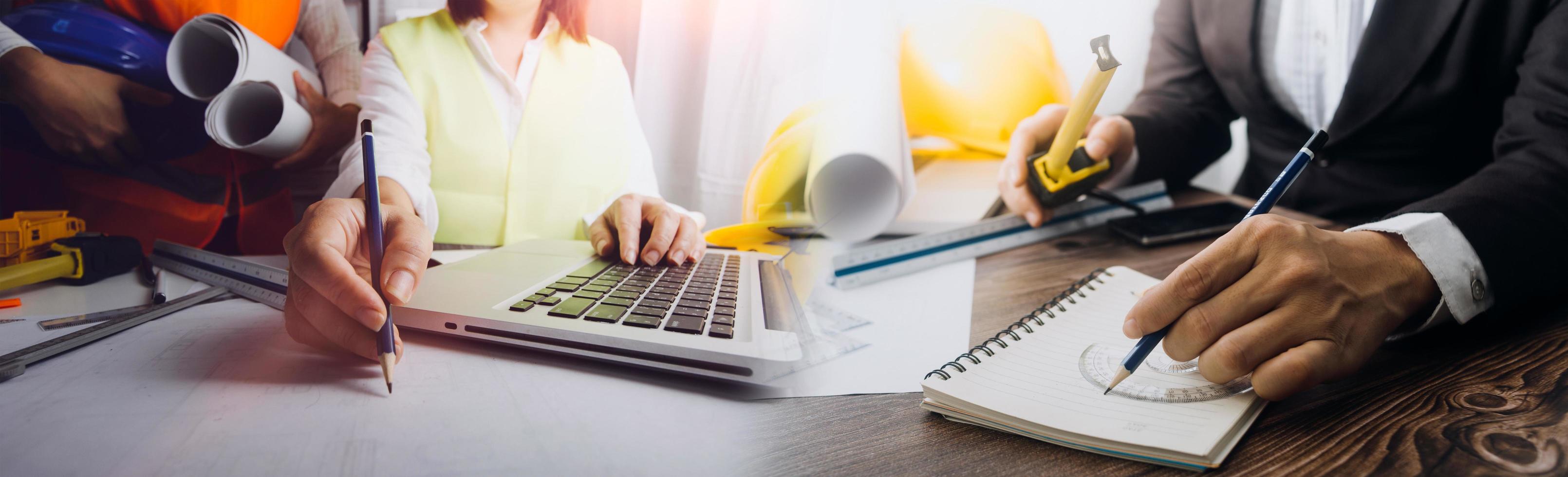 Deux collègues discutant des données de travail et tablette, ordinateur portable avec sur le projet architectural sur le chantier de construction au bureau au bureau photo