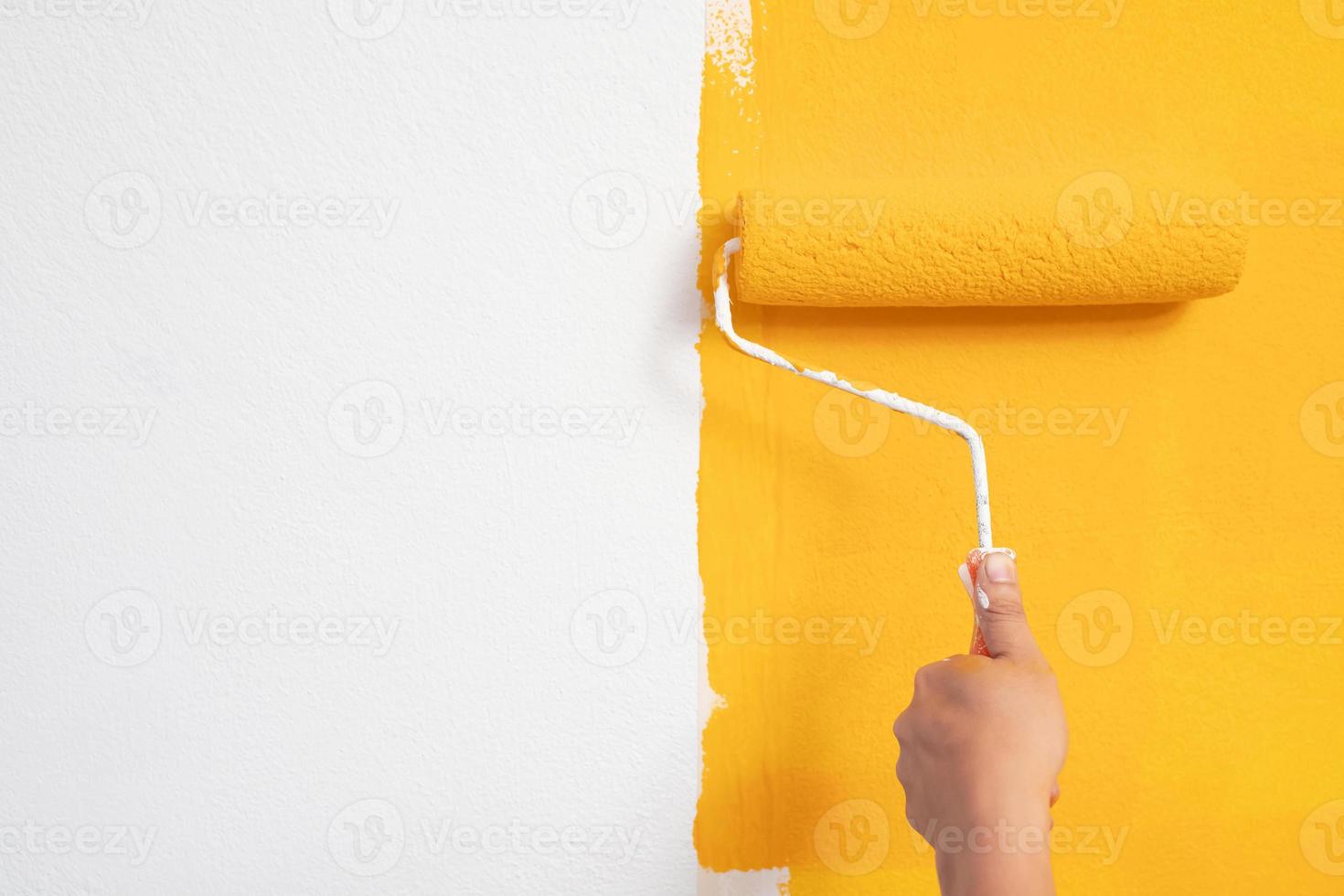 le mécanicien peint du jaune sur le mur. photo