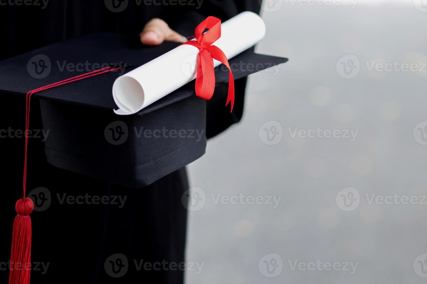 remise des diplômes, gros plan étudiant tenant chapeau pompon rouge avec certificat de diplôme en main pendant le début de la réussite des diplômés de l'université, diplôme de cérémonie de félicitations à l'éducation conceptuelle. photo