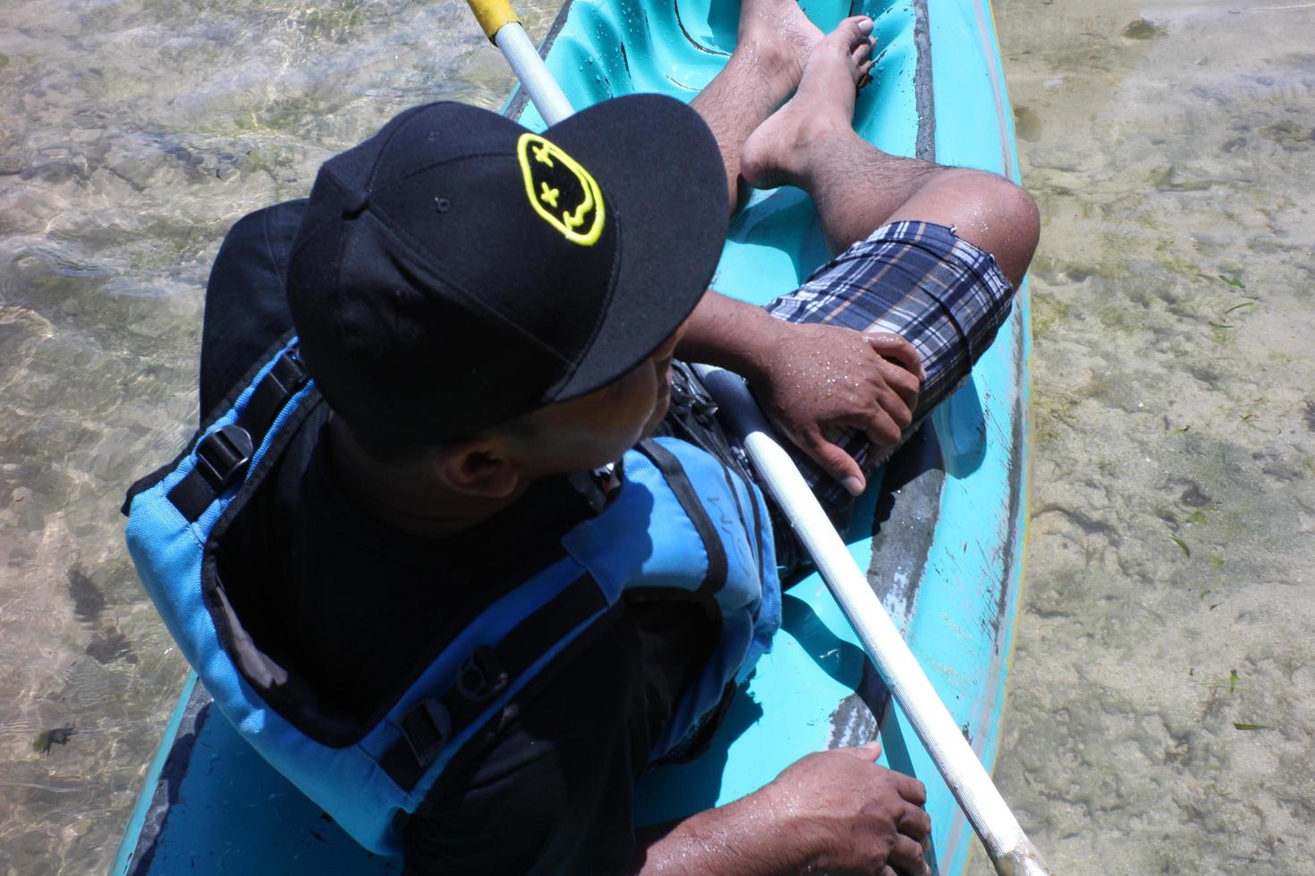 yogyakarta, indonésie 18 09 2022 .un homme prend un bain de soleil sur un petit bateau bleu. photo