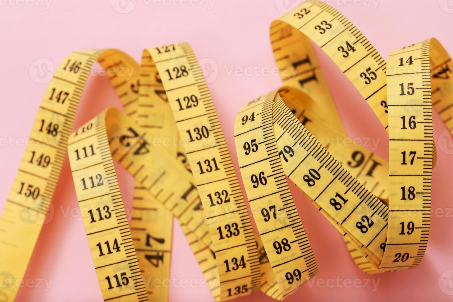 Ruban à mesurer pour les personnes obèses sur fond rose soft focus photo