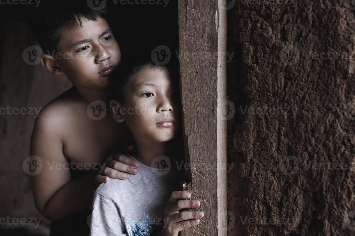 gros plan pauvre garçon qui sort d'une maison délabrée, concept d'assistance aux pauvres, droits de l'homme. photo