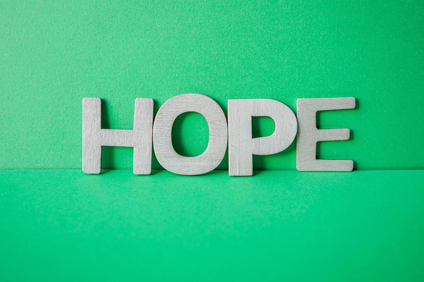 mot d'espoir avec des lettres en bois sur le fond vert photo