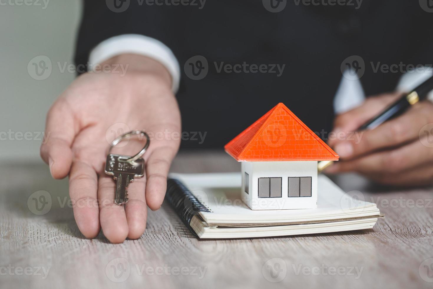 agent immobilier tenant la clé de la maison à son client après avoir signé un contrat au bureau, concept pour l'immobilier, location de biens photo