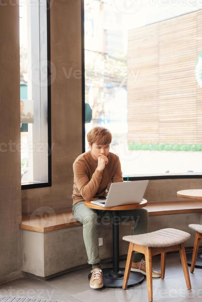 jeune homme étudiant et lisant au café photo