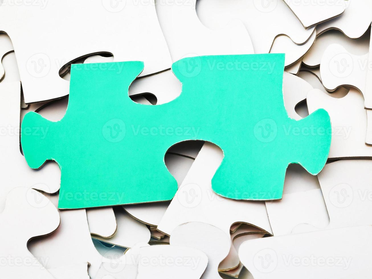 pièce verte séparée sur une pile de puzzles blancs photo