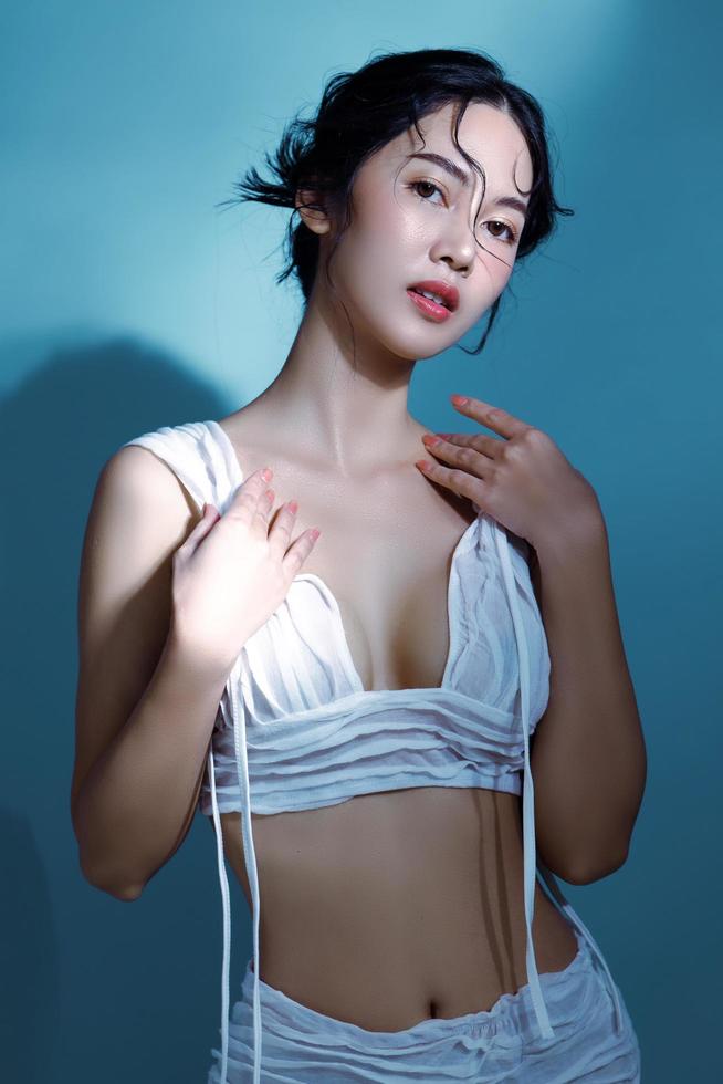 séduisante jeune femme asiatique cheveux mouillés modèle avec une peau fraîche parfaite sur la simulation sous-marine de l'éclairage soins du visage traitement du visage cosmétologie chirurgie plastique belle fille portrait en studio photo