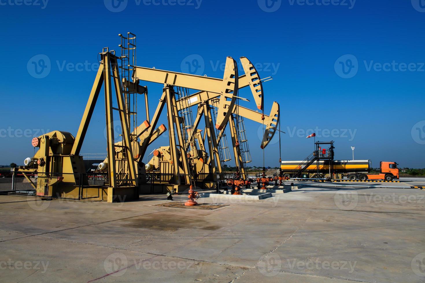 les plates-formes pétrolières et les camions pétroliers fonctionnent ou sont garés pour drainer le pétrole dans les champs pétrolifères. photo