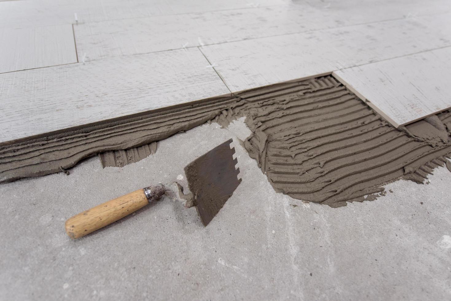 carreaux en céramique effet bois et outils pour carreleur au sol photo