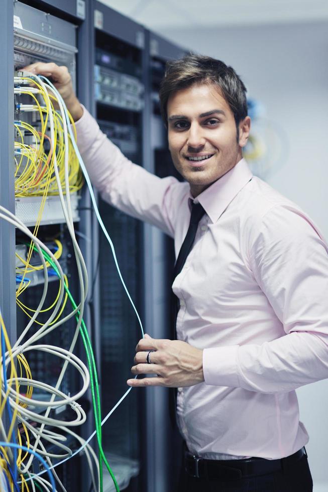 jeune ingénieur informatique dans la salle des serveurs du centre de données photo