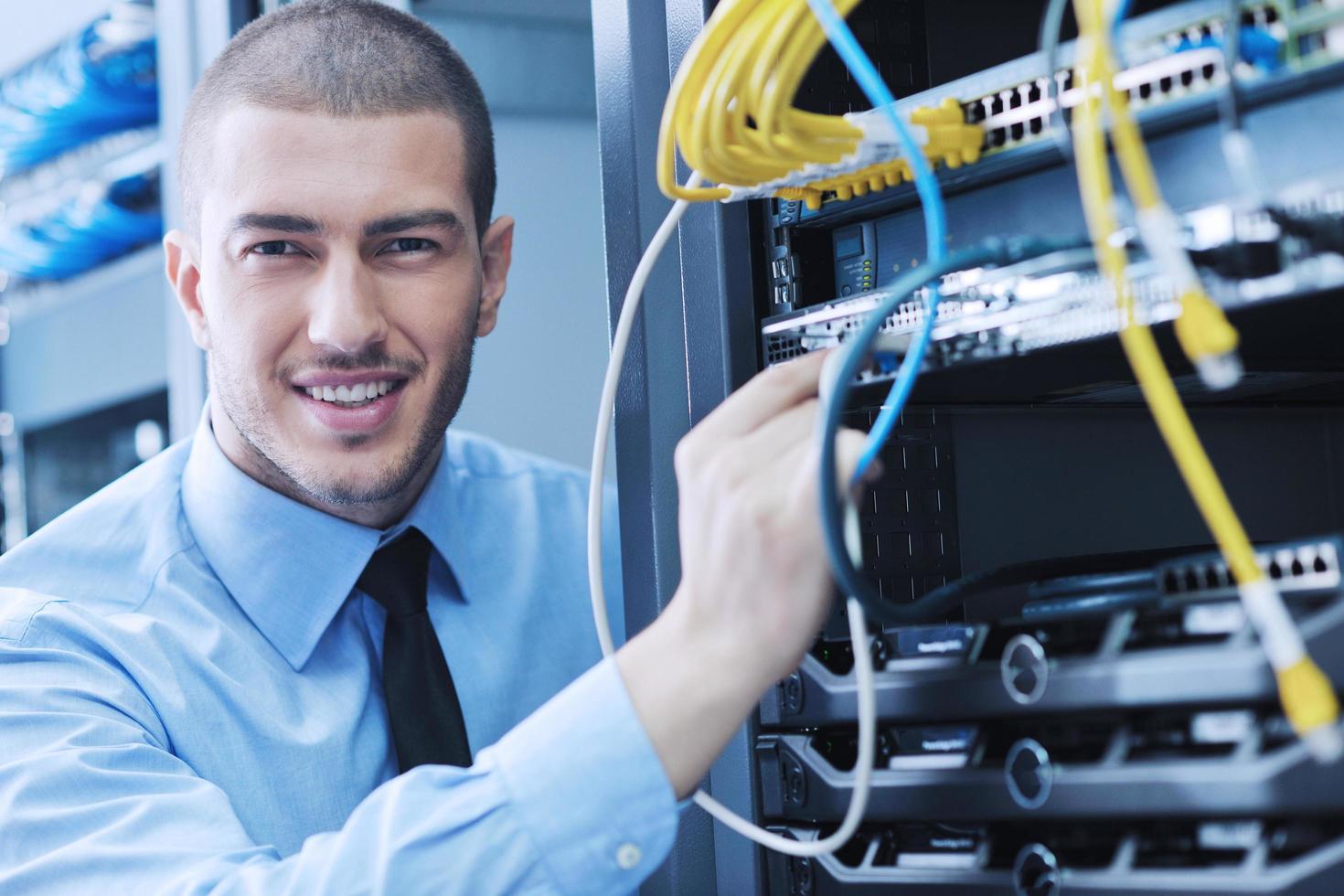 jeune ingénieur informatique dans la salle des serveurs du centre de données photo