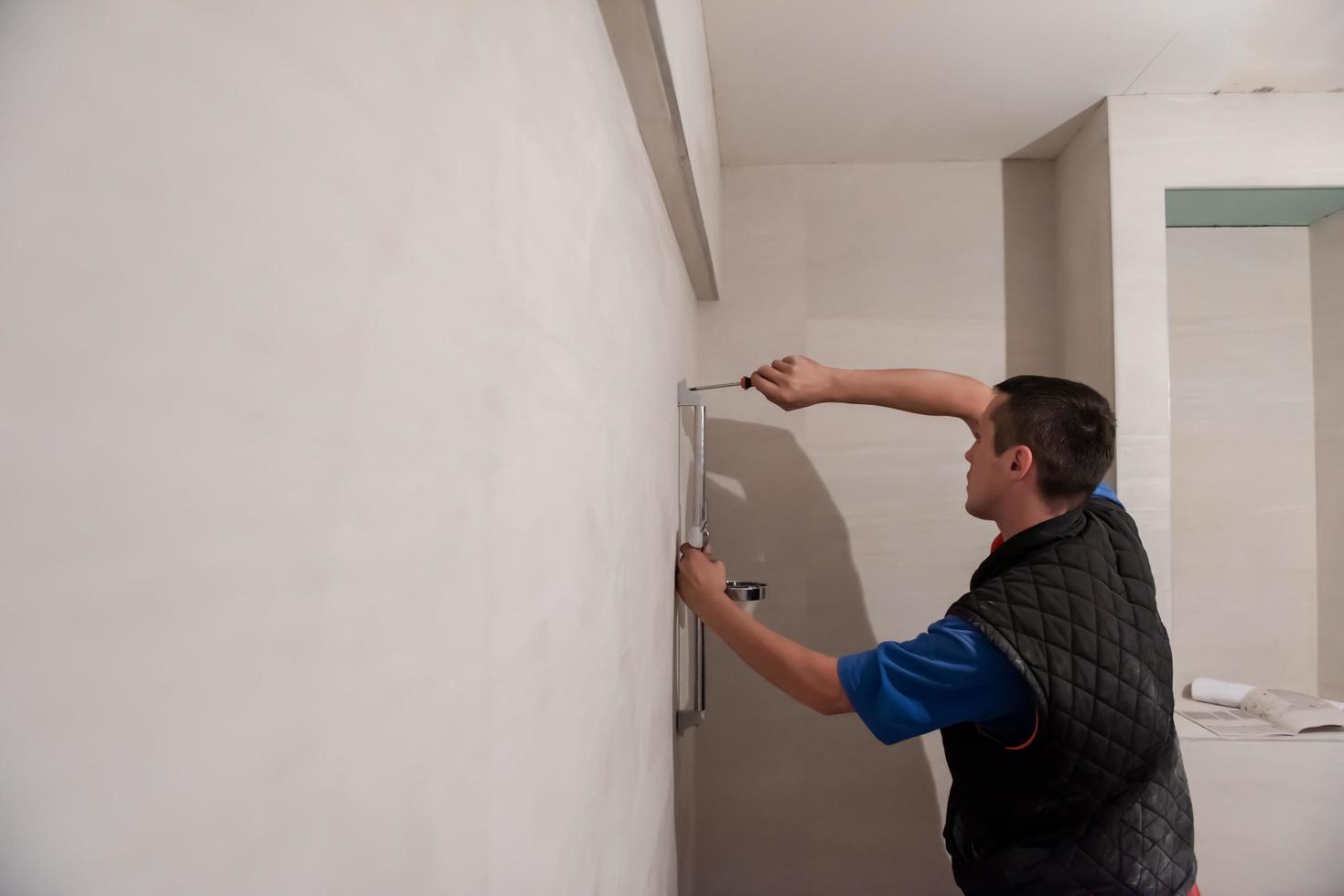 plombier professionnel travaillant dans une salle de bain photo