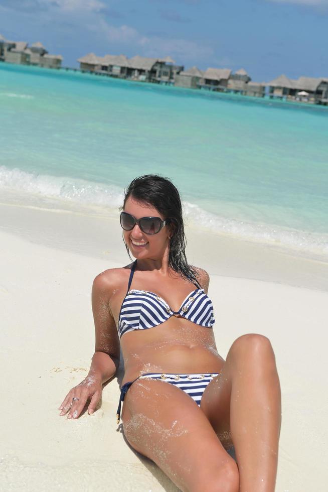 belle jeune femme sur la plage s'amuser et se détendre photo