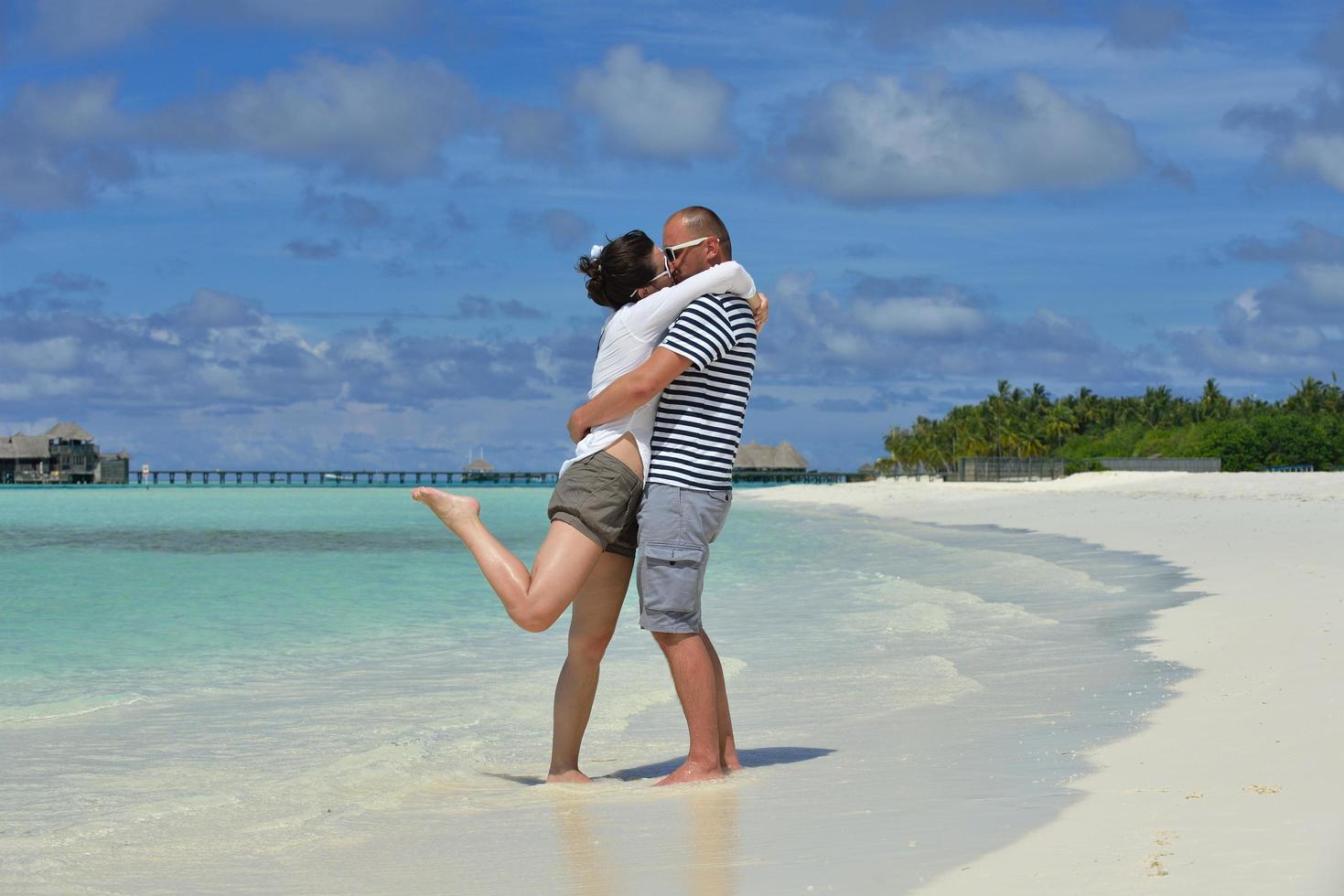 heureux jeune couple en vacances d'été s'amuser et se détendre à la plage photo