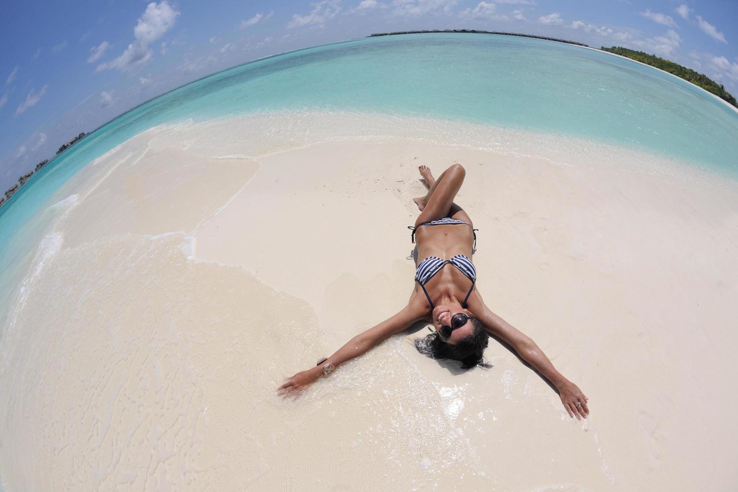 belle jeune femme sur la plage s'amuser et se détendre photo