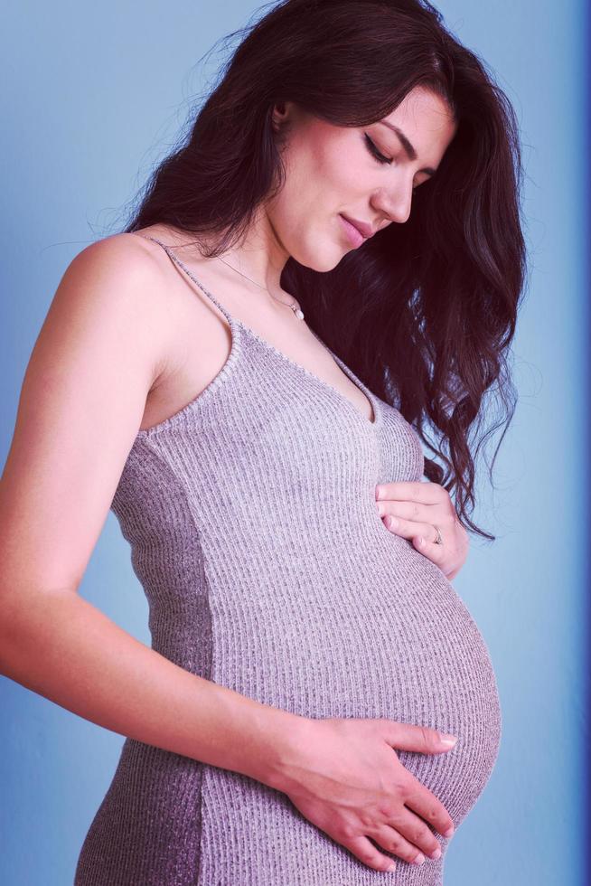 portrait de femme enceinte sur fond bleu photo