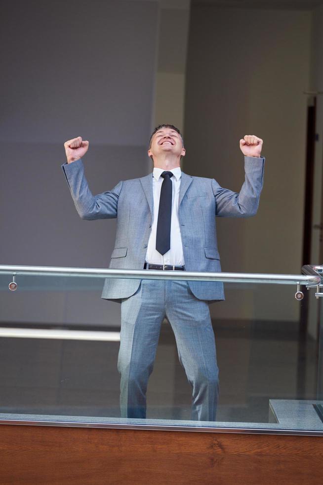 homme d'affaires heureux lève les mains de joie photo