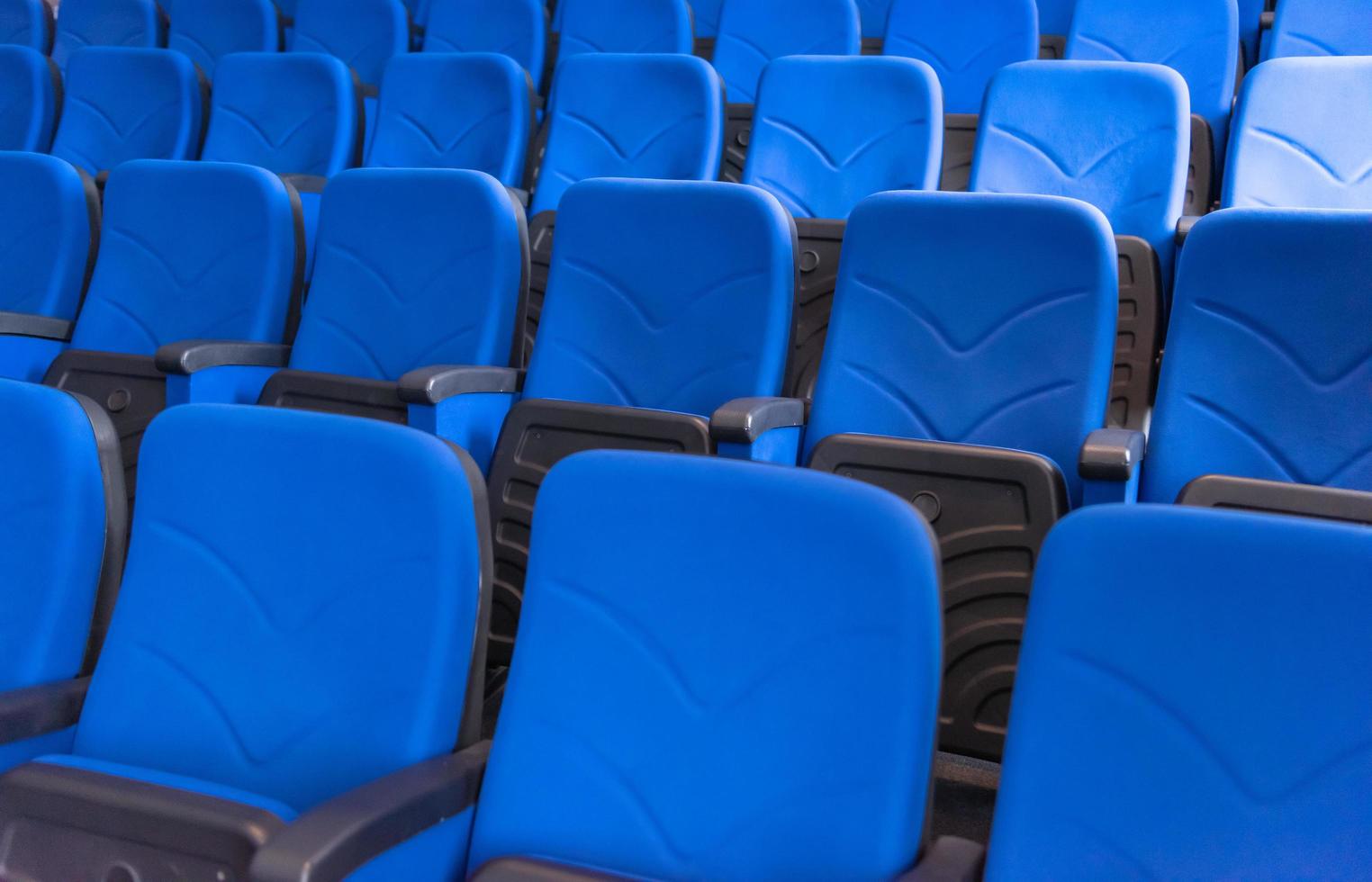 salle avec des rangées de sièges bleus photo