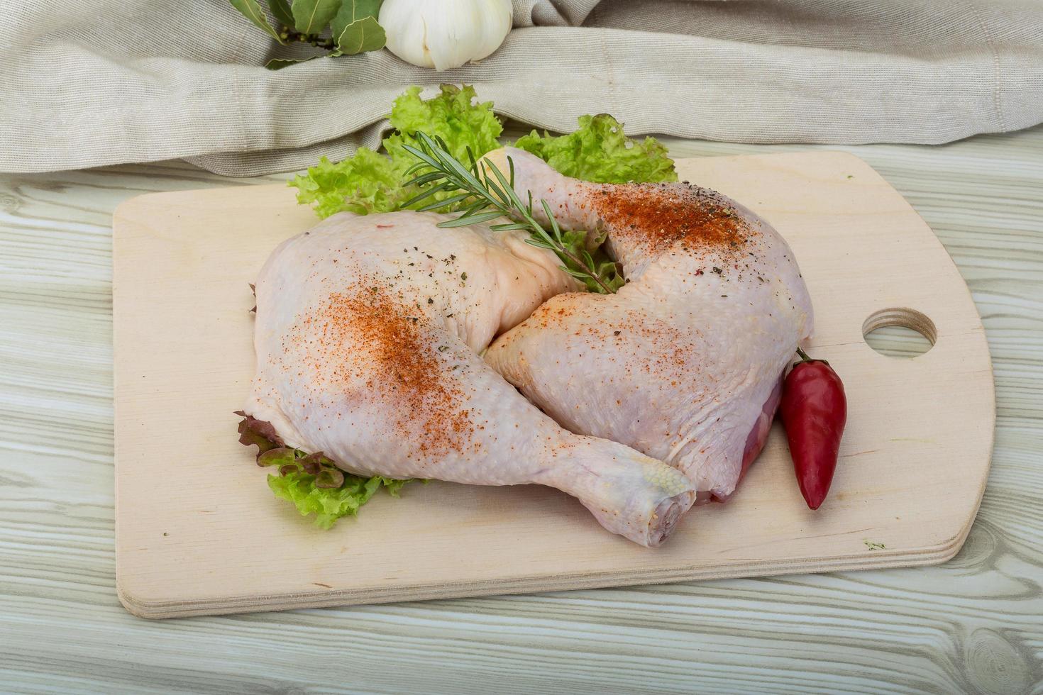 cuisse de poulet sur planche de bois et fond en bois photo