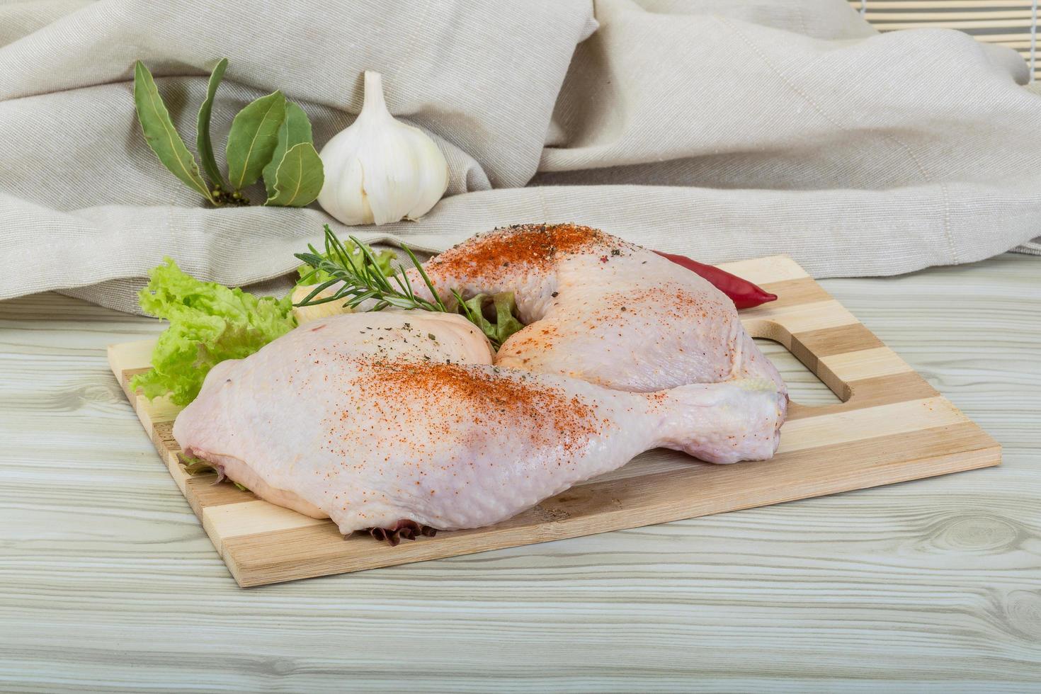 cuisse de poulet sur planche de bois et fond en bois photo