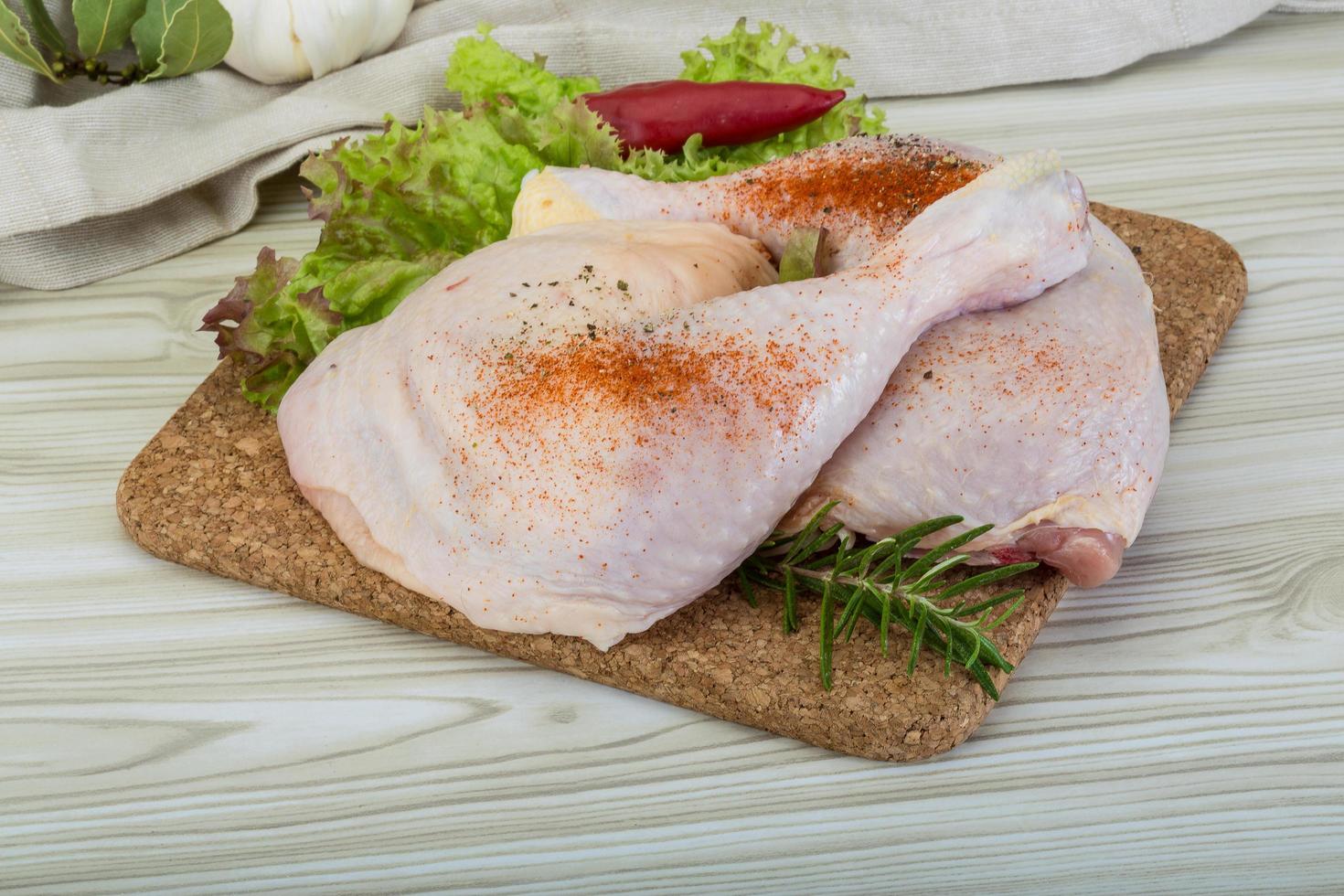 cuisse de poulet sur planche de bois et fond en bois photo