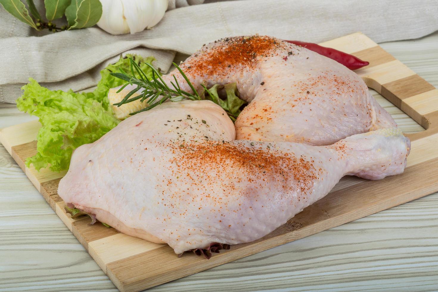 cuisse de poulet sur planche de bois et fond en bois photo