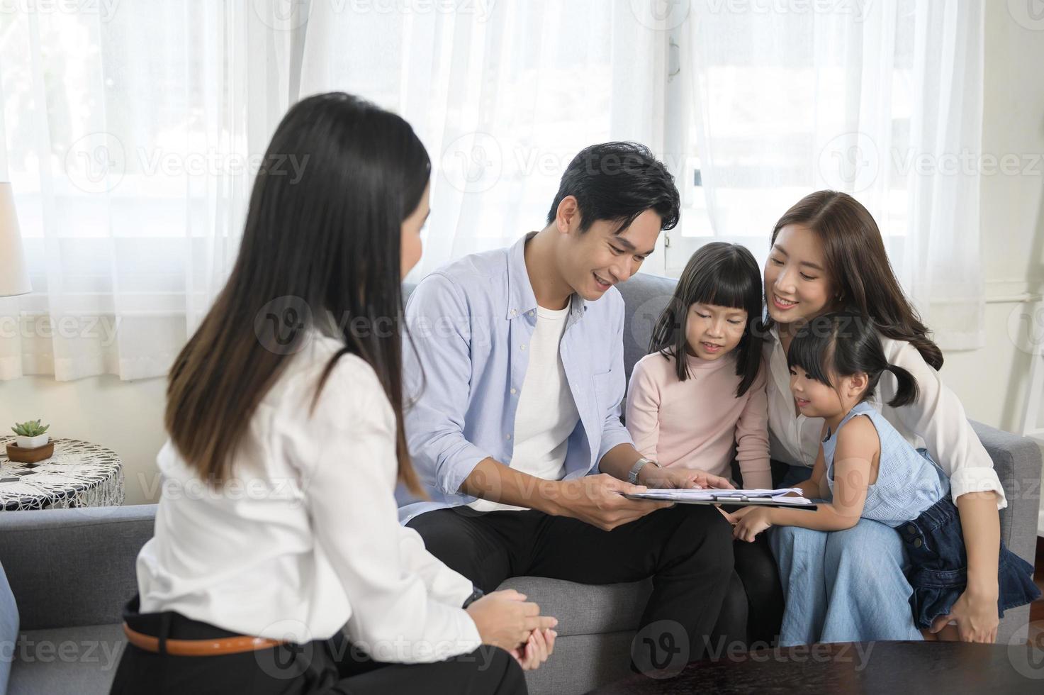 réunion de famille asiatique avec une femme agent immobilier ou consultant en assurance offrant des promotions, un prêt hypothécaire, un prêt, des biens et un concept d'assurance maladie. photo