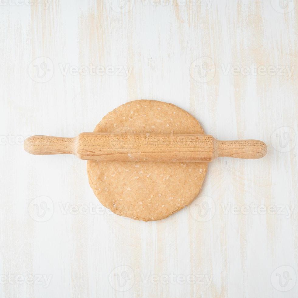 recette étape par étape. galette maison aux légumes. vue de dessus, table en bois blanc, pâte crue photo