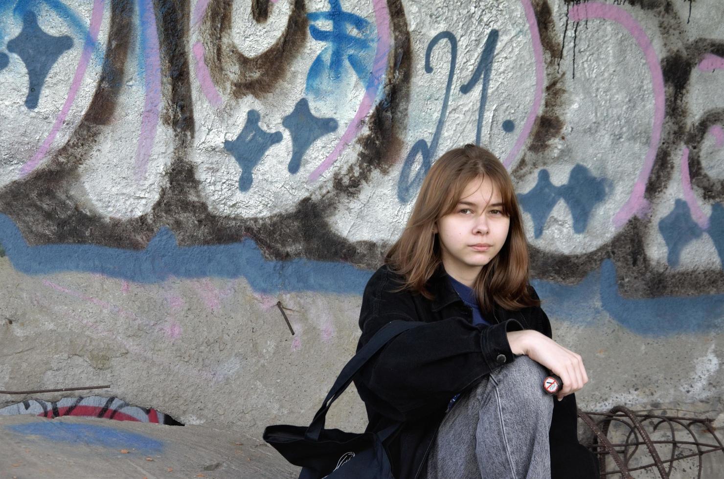 St. petersbourg, russie, 06.01.2022. une adolescente est assise dans un bâtiment abandonné peint de graffitis et fume photo