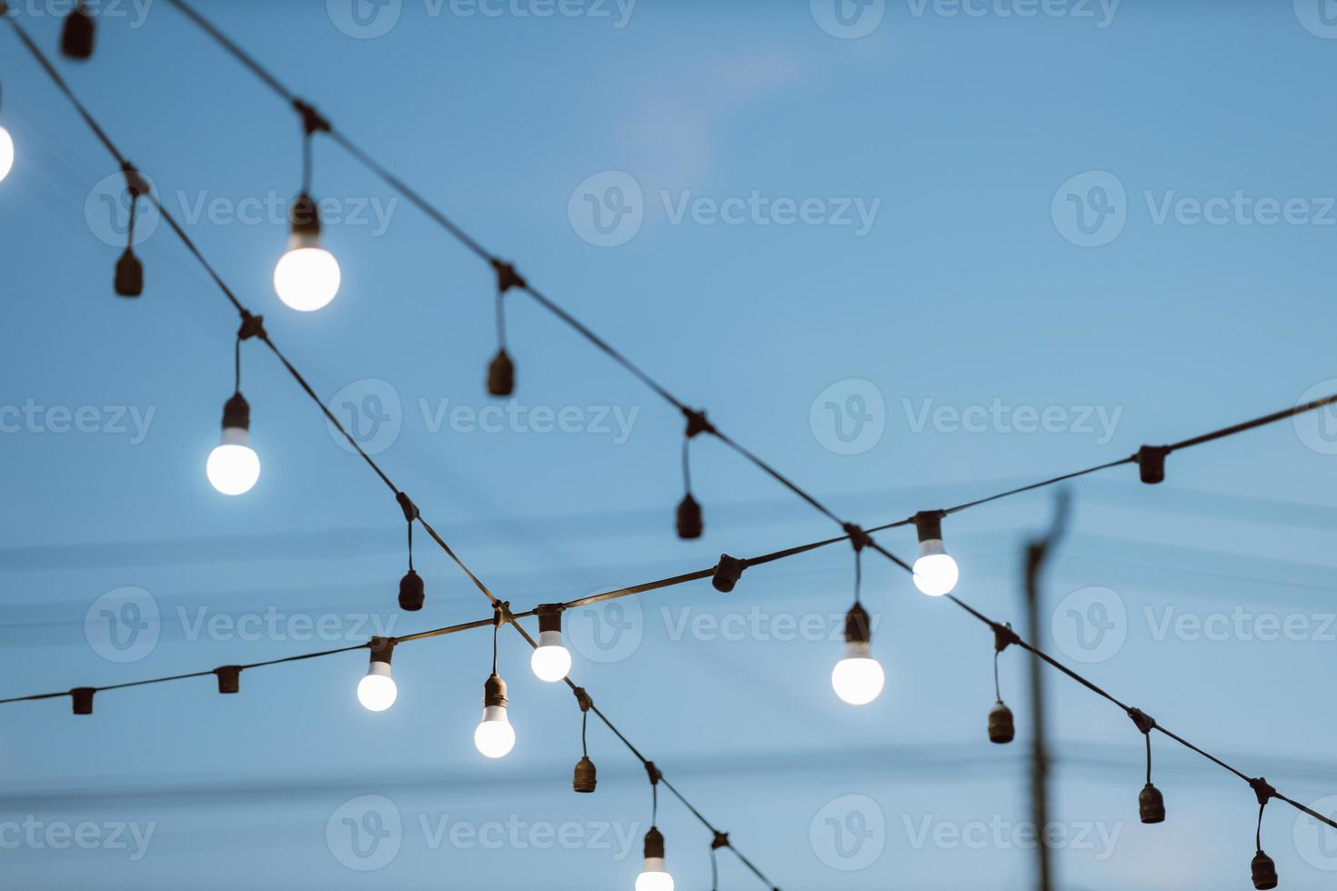 décor d'ampoule sur ciel bleu dans la fête en plein air. photo