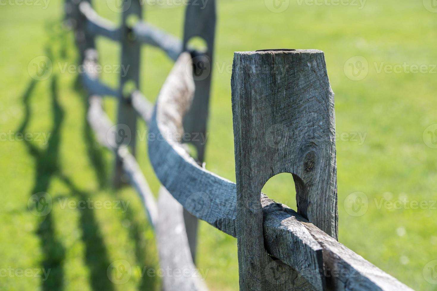 vieille clôture en bois sur fond d'herbe verte photo