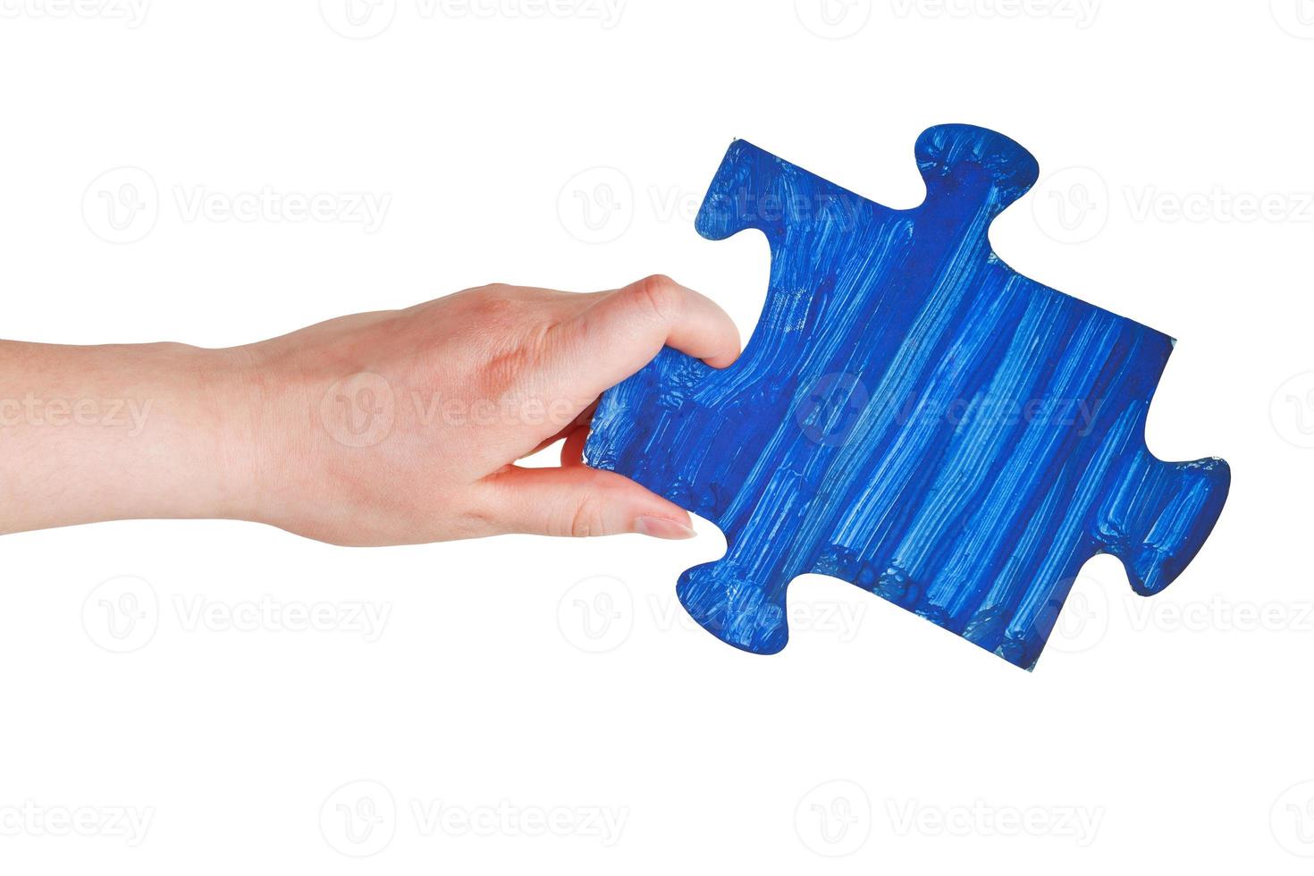 main féminine avec pièce de puzzle peinte en bleu photo