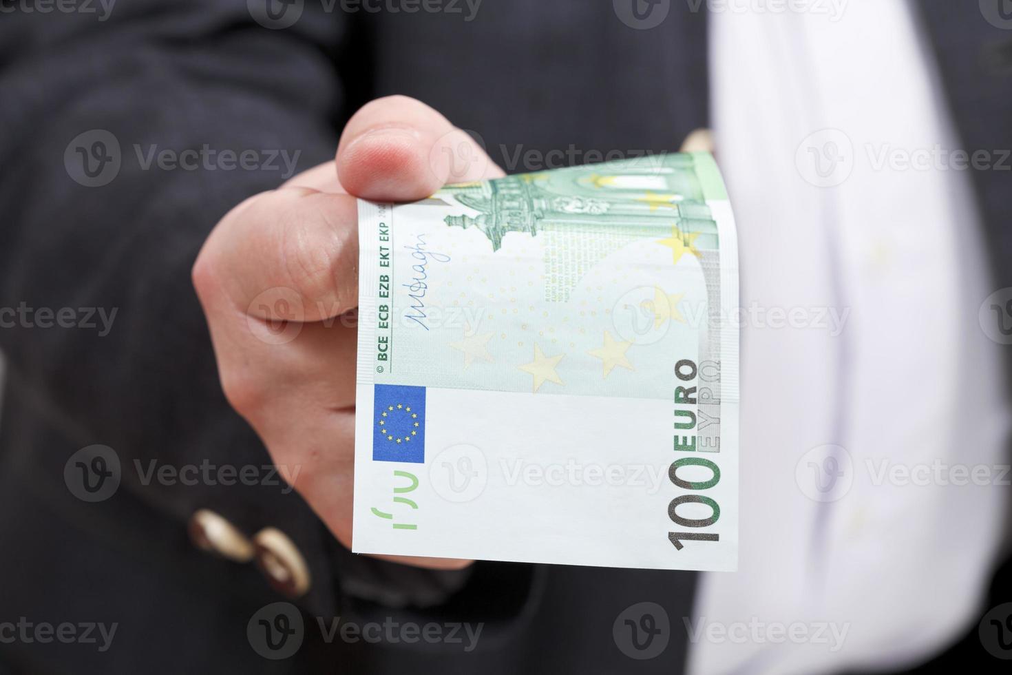 vue de face billet de 100 euros dans la main de l'homme d'affaires photo