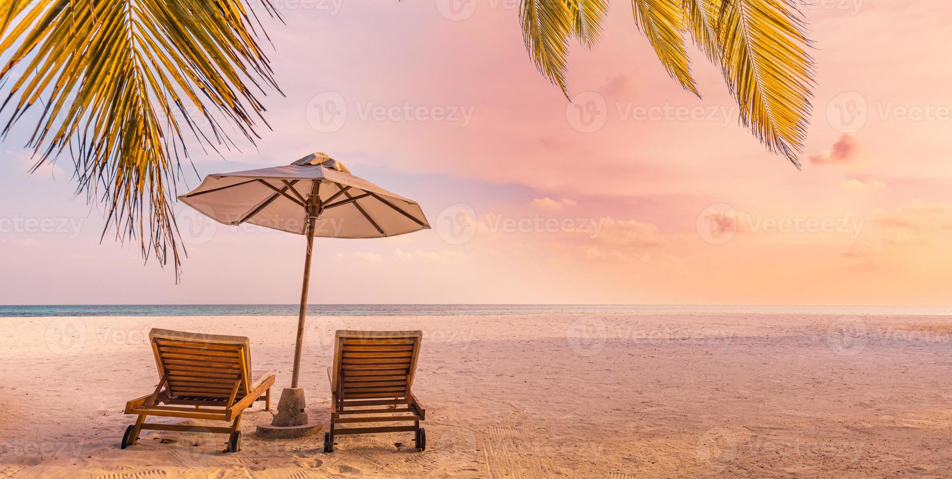 belle nature panoramique. coucher de soleil sur la plage tropicale comme paysage d'île d'été avec chaises parasol feuilles de palmier calme bord de mer, côte. bannière de destination panoramique de voyage de luxe pour des vacances ou des vacances photo