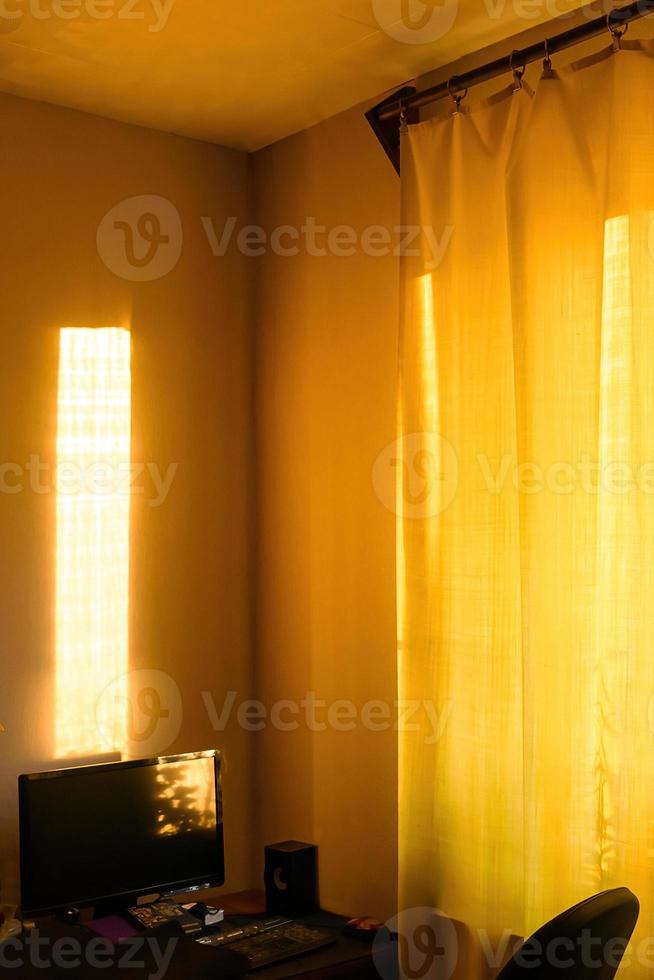 les rayons du soleil au coucher du soleil tombent sur le bureau de l'ordinateur dans l'appartement. photo