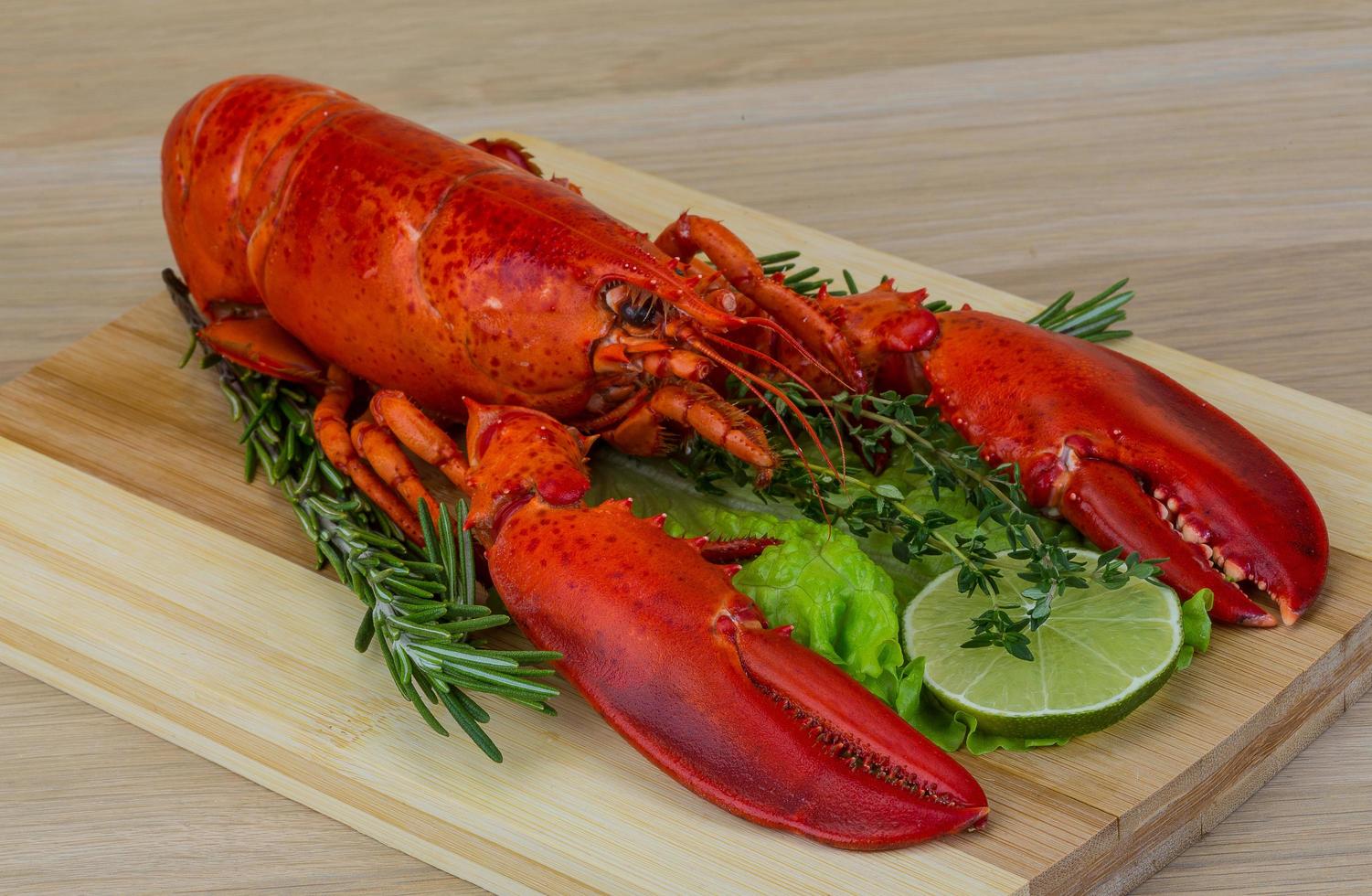 Homard bouilli sur planche de bois et fond de bois photo