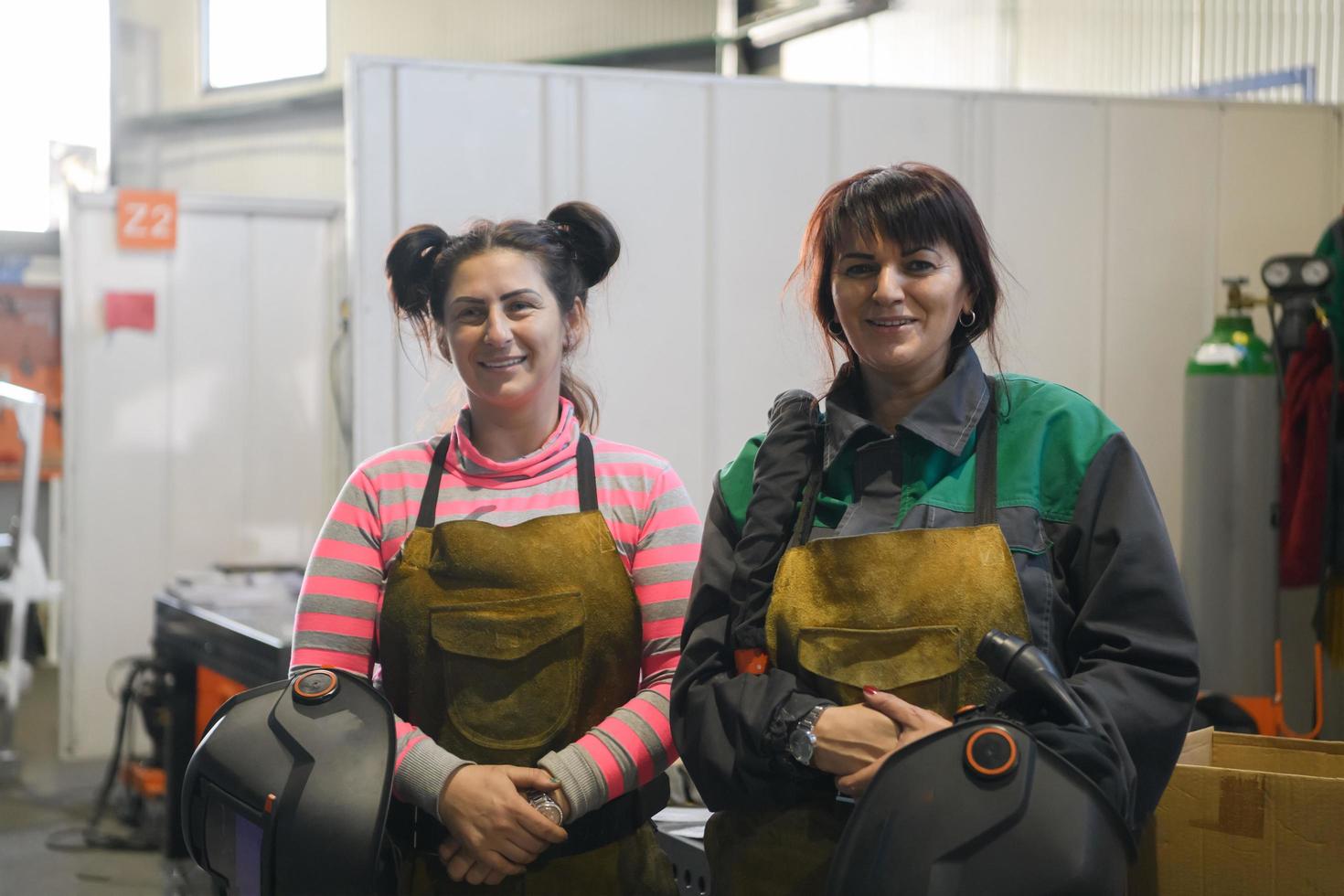 portrait de deux soudeurs tenant des masques de soudage dans leurs mains et se préparant à travailler dur dans une usine photo